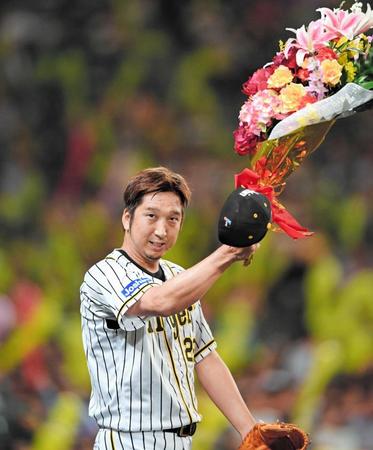 　７回を無失点に抑えた藤川は７００試合登板を達成。花束を掲げて声援に応える（撮影・田中太一）