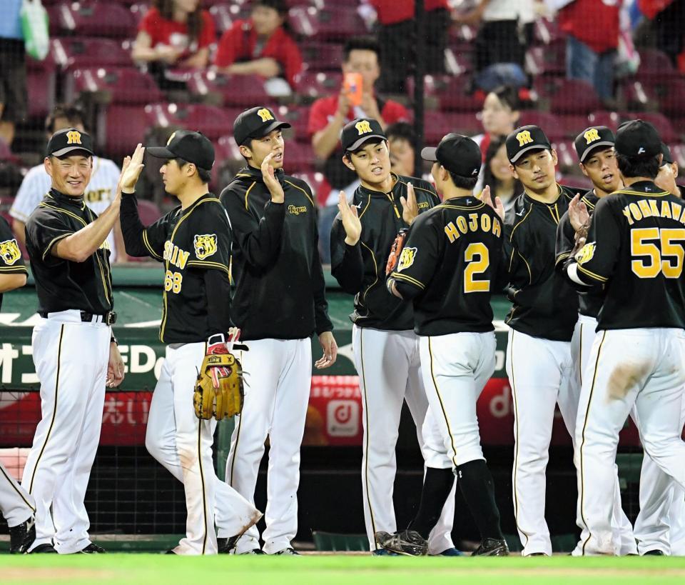 勝利のハイタッチでナインを迎える（左から）阪神・金本知憲監督、阪神・才木浩人ら阪神ナイン＝マツダスタジアム（撮影・飯室逸平）