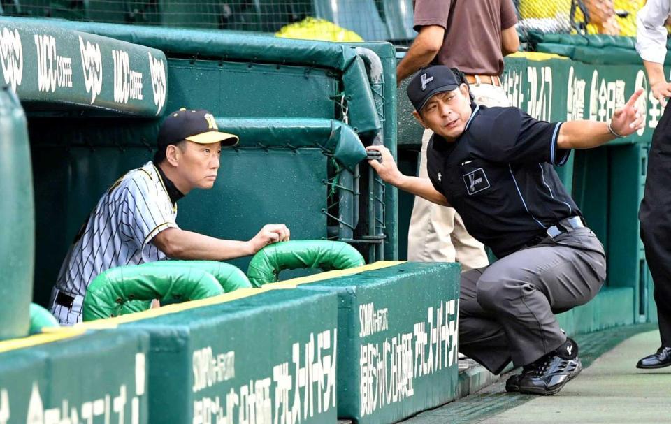 　中断中に真鍋球審（右）から説明を受ける金本監督（撮影・持木克友）