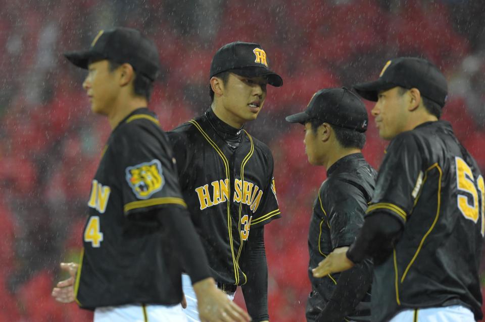 ２回、無失点に抑え、雨の中ベンチに戻る阪神・才木浩人＝マツダスタジアム（撮影・北村雅宏）