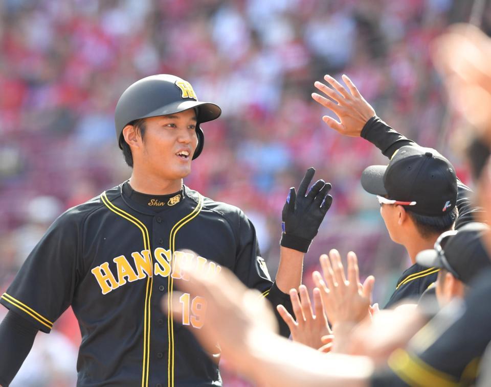 ３回、阪神・糸原の適時三塁打で生還し、ナインとタッチを交わす阪神・藤浪＝マツダスタジアム（撮影・北村雅宏）