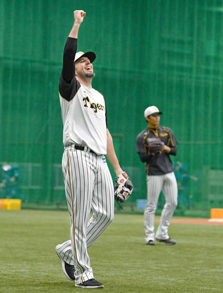 　キャッチボール中に笑顔で拳を突き上げるメッセンジャー。右奥は藤浪