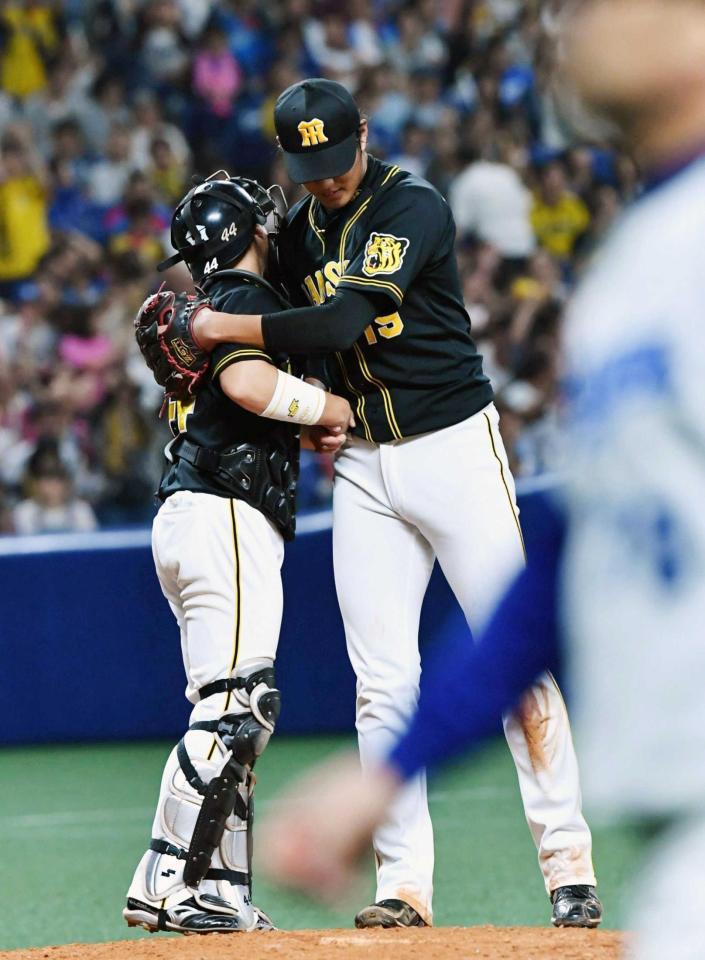 　完封勝利を挙げ梅野（左）と抱き合う藤浪