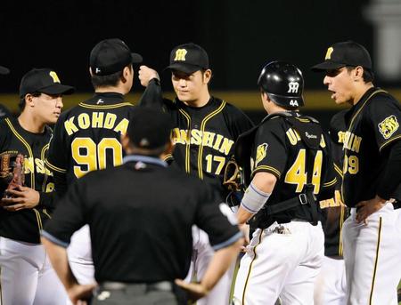 　１回、ピンチを迎え、香田コーチ（左から２人目）と話をする岩貞（同３人目）＝撮影・田中太一