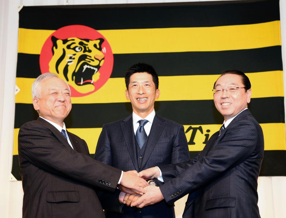 　就任会見を終え笑顔で握手する（左から）藤原崇起次期オーナー、矢野監督、揚塩球団社長＝大阪市内（撮影・山口登）