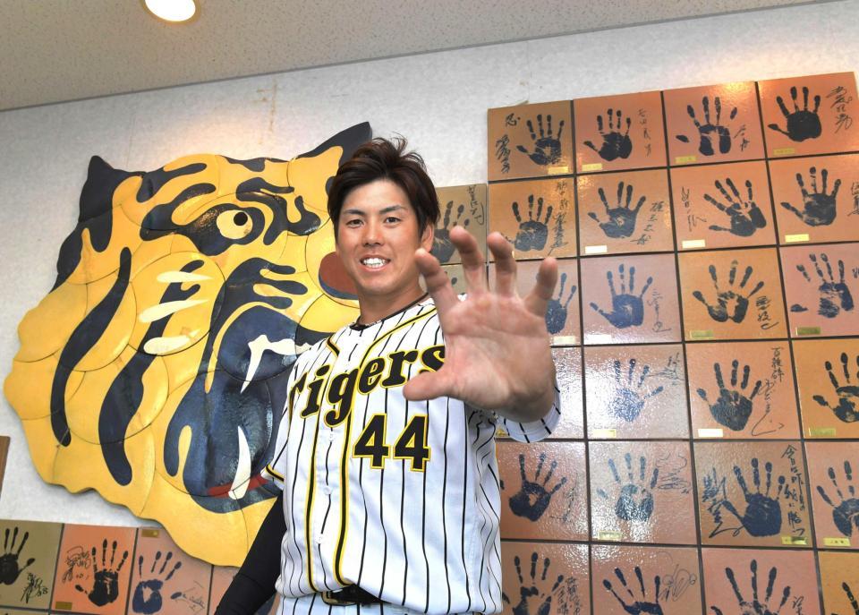 　阪神捕手として８年ぶりにゴールデングラブ賞を獲得し、左手を突き出す梅野（撮影・北村雅宏）