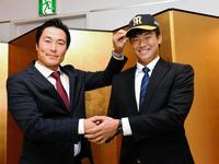 　阪神・筒井担当スカウト（左）から帽子をかぶせてもらう湯浅京己＝ホテルニューオータニ高岡