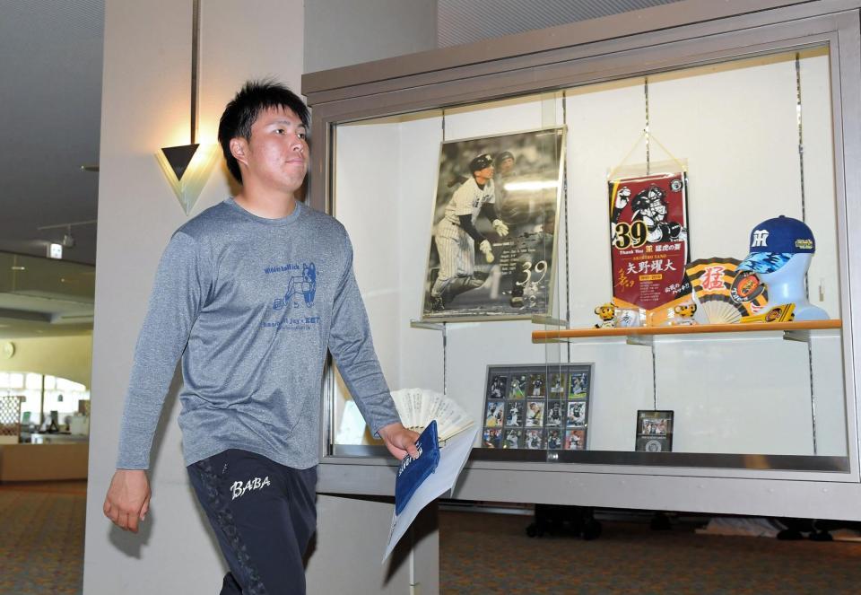 阪神・矢野燿大監督の現役時代のグッズを横目に自室に戻る阪神・馬場皐輔＝芸西村のホテル（撮影・高部洋祐）