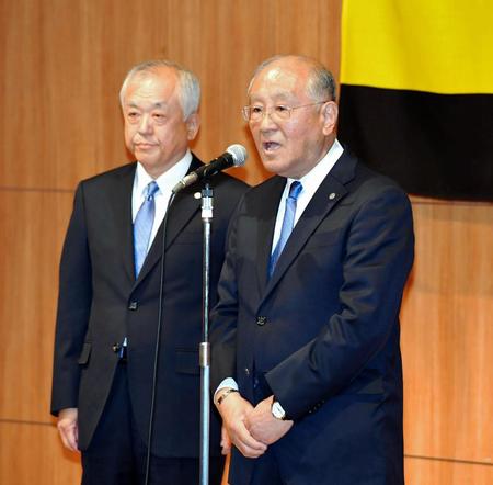 　阪神・藤原崇起次期オーナー（左）と共に壇上に上がり、挨拶する坂井信也オーナー＝大阪市内のホテル