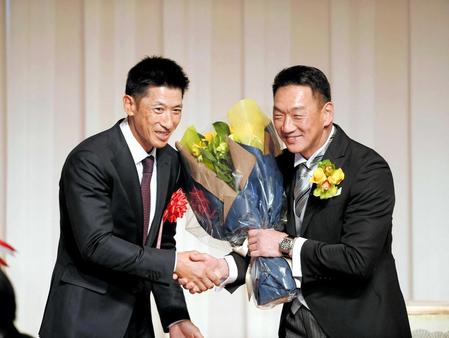 　金本知憲氏（右）に花束を手渡し、握手を交わす矢野監督