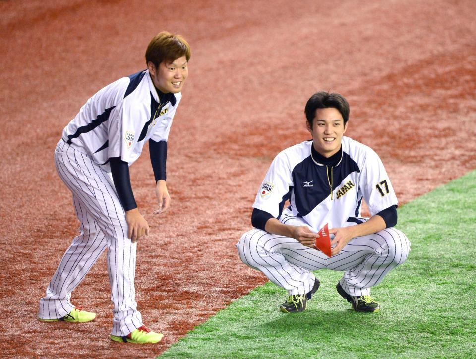 　日米野球第３戦の試合前練習で、談笑する藤浪（右）と西＝２０１４年