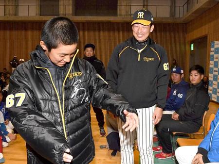 　抽選会で、笑顔で少年にジャンパーをプレゼントする岩崎