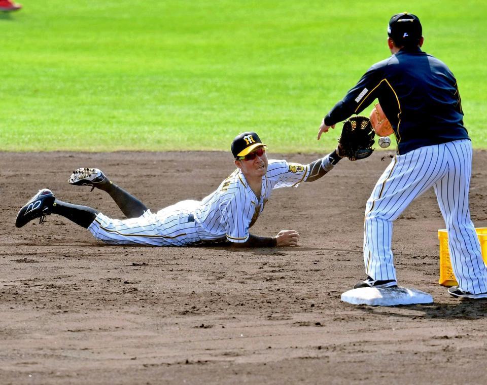 　遊撃を守ってノックの打球を好捕し、グラブトスをする鳥谷