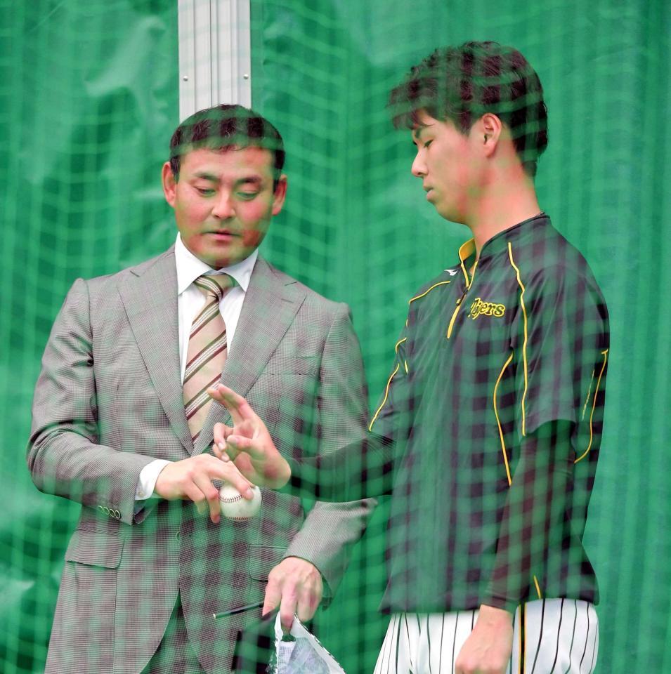 　川上憲伸氏（左）からボールの握りを教わる浜地（撮影・北村雅宏）
