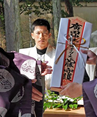 手渡される必勝祈願の札を見つめる矢野監督（撮影・高部洋祐）