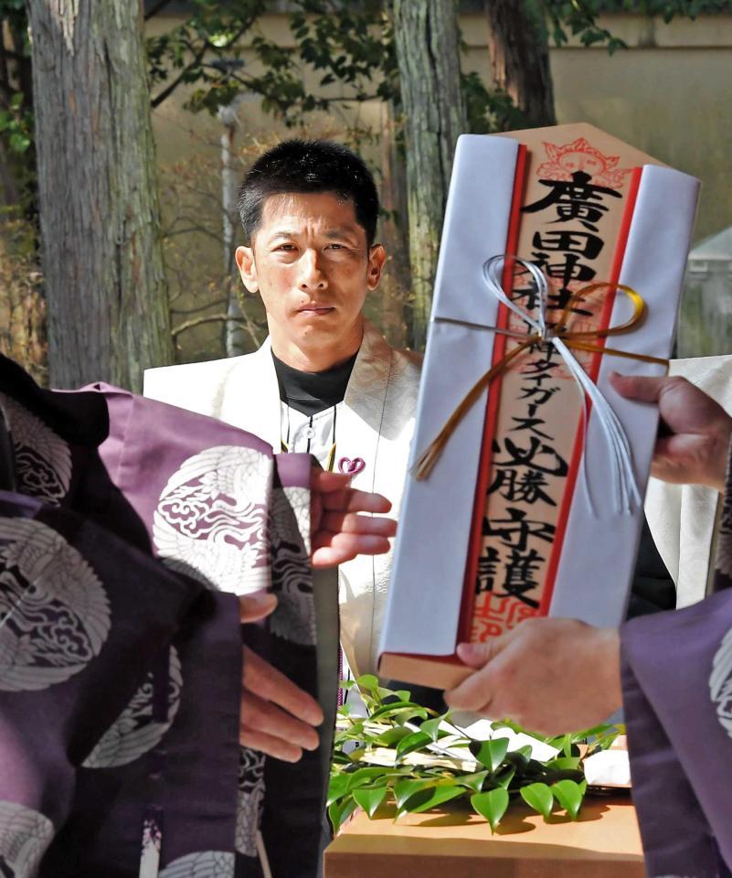 手渡される必勝祈願の札を見つめる矢野監督（撮影・高部洋祐）