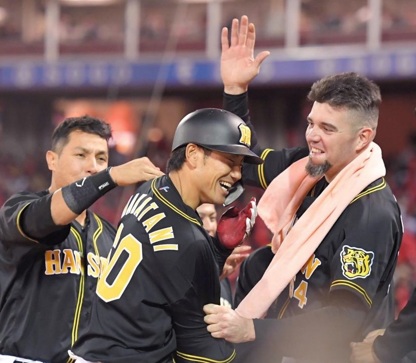７回、逆転となる２ランを放ち、メッセンジャー（右）に祝福される中谷（中央）＝撮影・北村雅宏