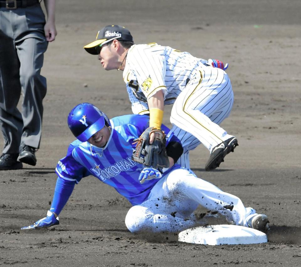 ２回、大山の二塁悪送球で交錯するソト（下）と糸原
