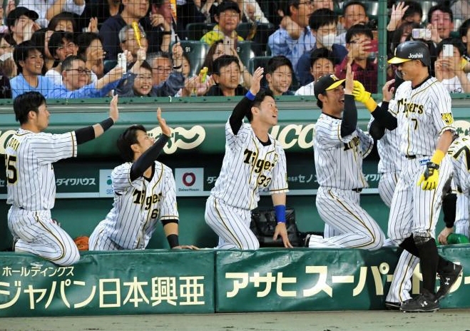 　７回、生還し、ナインとタッチを交わす阪神・糸井＝甲子園（撮影・高部洋祐）