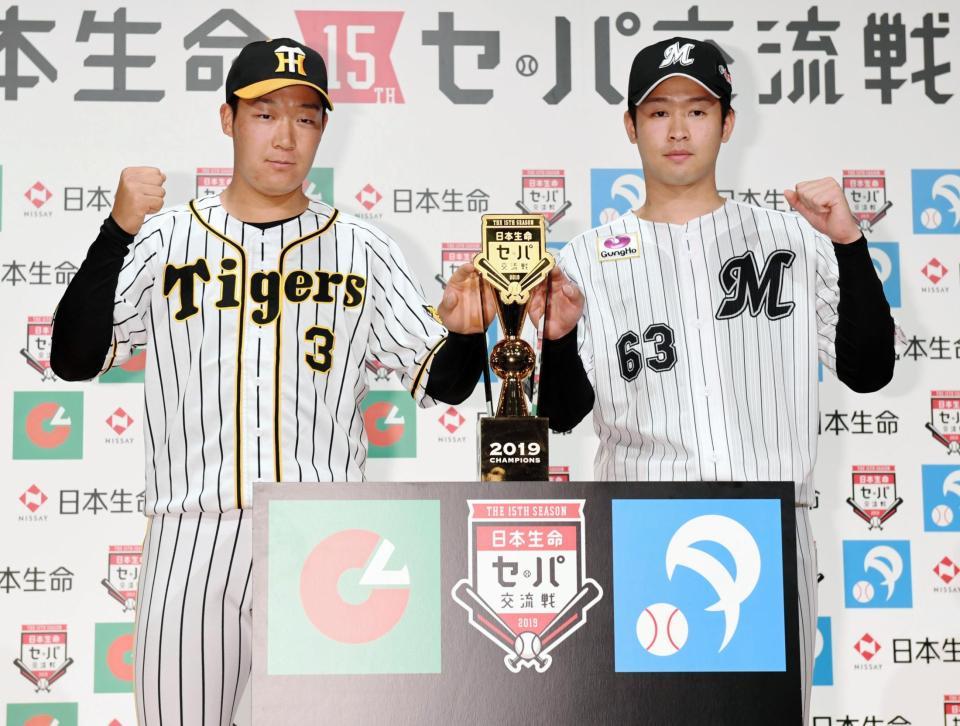 優勝トロフィーを前にガッツポーズする阪神・大山悠輔（左）とロッテ・種市＝都内（撮影・棚橋慶太）