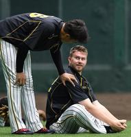 　練習中、秋山拓巳（左）に声をかけられる阪神・ジョンソン＝甲子園