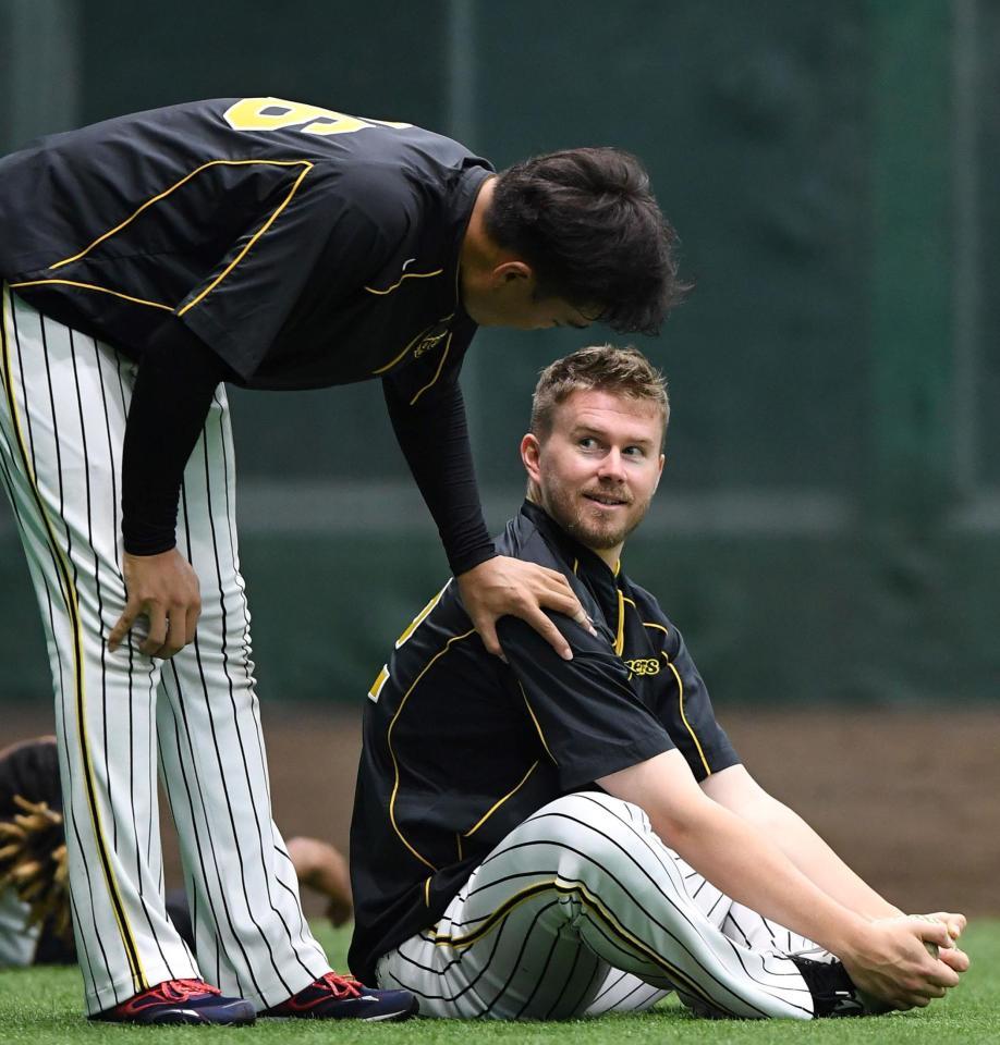 　練習中、秋山拓巳（左）に声をかけられる阪神・ジョンソン＝甲子園