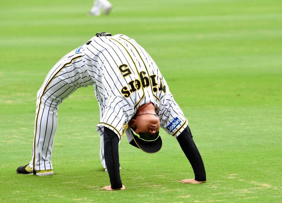 　ブリッジをして入念にウオーミングアップをする近本