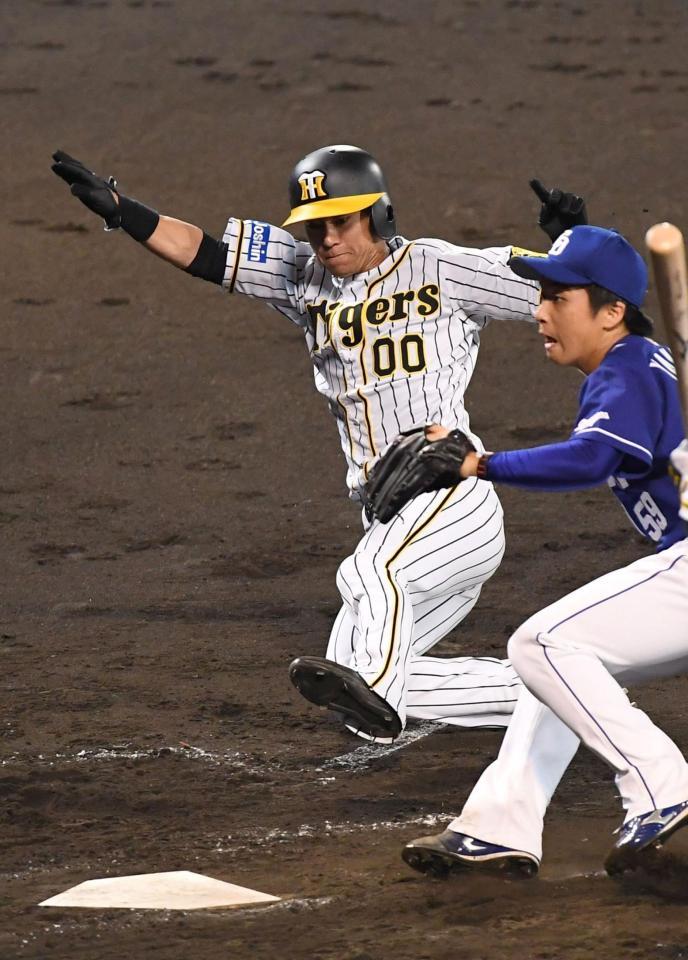 　５回、暴投の間に本塁へ生還する阪神・上本博紀