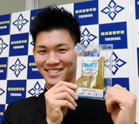 阪神・矢野燿大監督のサインが入ったドラフトＩＤを手に笑顔の横浜・及川雅貴＝横浜高校（撮影・棚橋慶太）