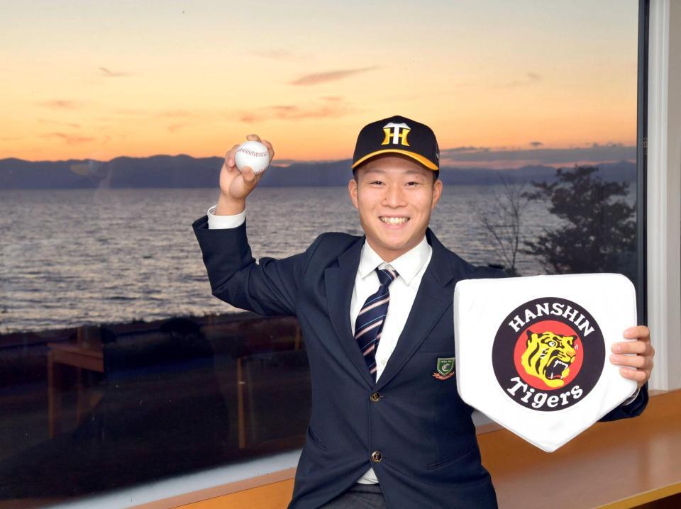 　夕焼けの琵琶湖を背に、阪神と仮契約を結んだドラフト５位指名の中京学院大中京・藤田（撮影・立川洋一郎）