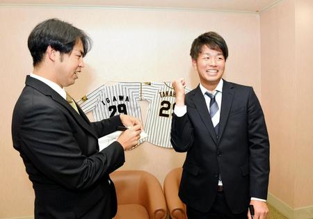 　井川氏（左）にサインを書いてもらいガッツポーズをして喜ぶ高橋