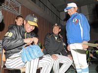 プレゼントするグラブに書いたサインを失敗し、苦笑いする高橋遥（左）と岩崎