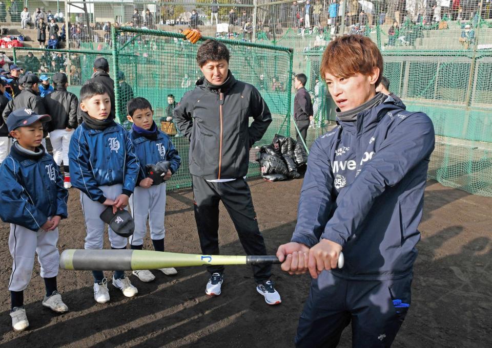 　野球教室でバットの振り方を指導する上本。中央奥は俊介