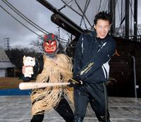 　猛吹雪のなか記者の扮（ふん）するなまはげの前でバットを振る遠藤