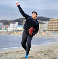 　逗子海岸を背にキャッチボールする小川