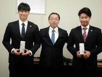 揚塩健治球団社長（中央）から記念品を手渡された牧（右）と湯浅