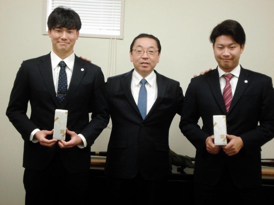 揚塩健治球団社長（中央）から記念品を手渡された牧（右）と湯浅