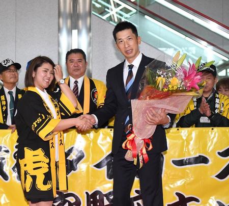 沖縄に到着し、花束を受け取った阪神・矢野燿大監督（右）は関係者と握手を交わす＝那覇空港（撮影・北村雅宏）
