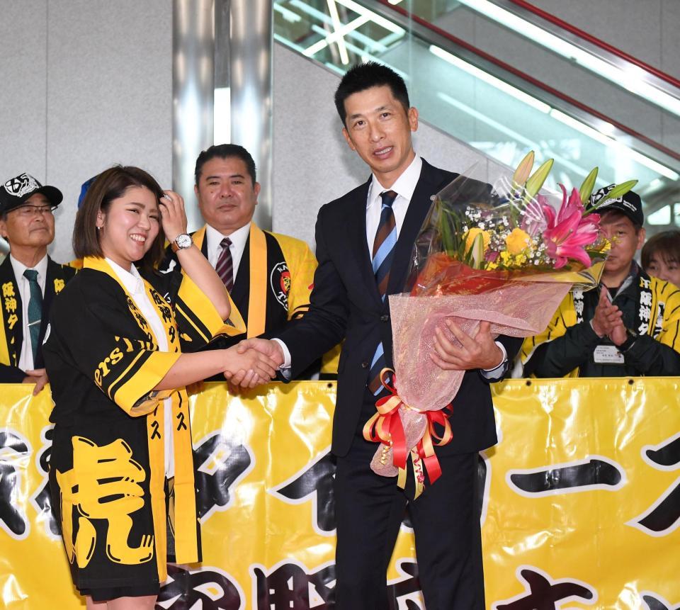 沖縄に到着し、花束を受け取った阪神・矢野燿大監督（右）は関係者と握手を交わす＝那覇空港（撮影・北村雅宏）