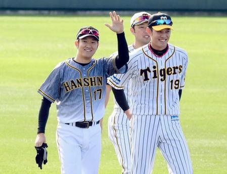 キャンプ初日、１日キャプテンとなった阪神・岩貞祐太（左）はスタンドに手を振る。右は阪神・藤浪晋太郎＝宜野座（撮影・田中太一）