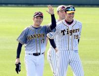 キャンプ初日、１日キャプテンとなった阪神・岩貞祐太（左）はスタンドに手を振る。右は阪神・藤浪晋太郎＝宜野座（撮影・田中太一）