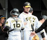 ２イニングを無失点に抑え阪神・坂本誠志郎（左）とタッチする阪神・藤浪晋太郎＝かりゆしホテルズボールパーク宜野座（撮影・棚橋慶太）