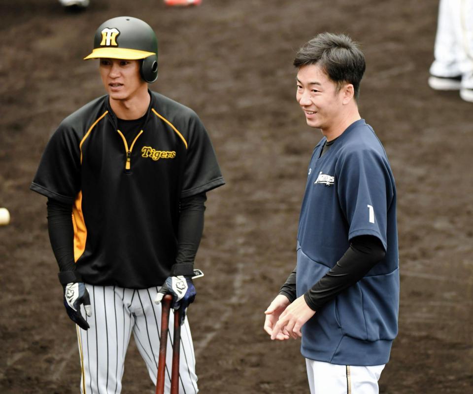 阪神・上本博紀（左）と談笑する日本ハム・斎藤佑樹＝かりゆしホテルズボールパーク宜野座（撮影・棚橋慶太）