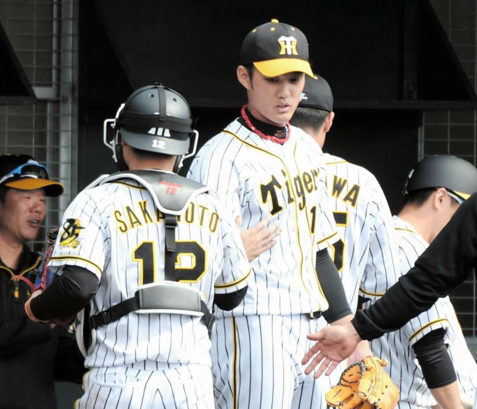 ２イニングを無失点に抑え阪神・坂本誠志郎（左）とタッチする阪神・藤浪晋太郎＝かりゆしホテルズボールパーク宜野座（撮影・棚橋慶太）