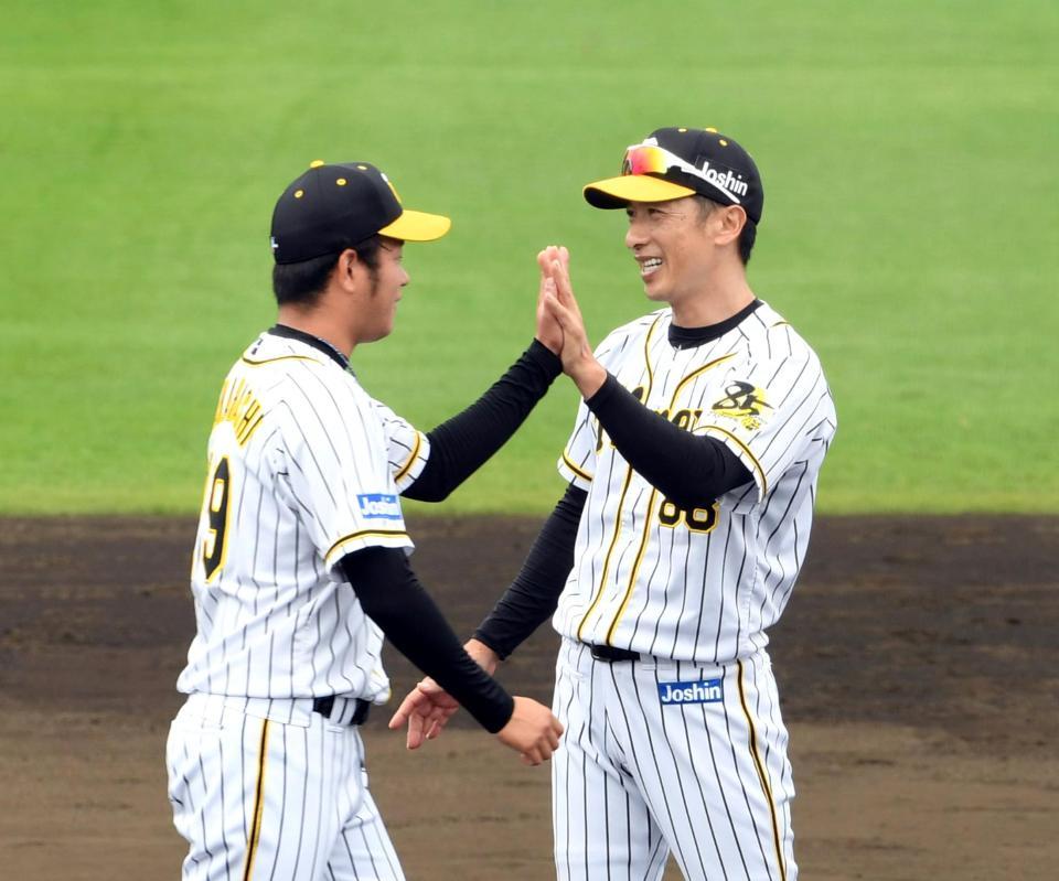 　キャンプを打ち上げ矢野監督（右）は高橋とハイタッチする（撮影・山口登）