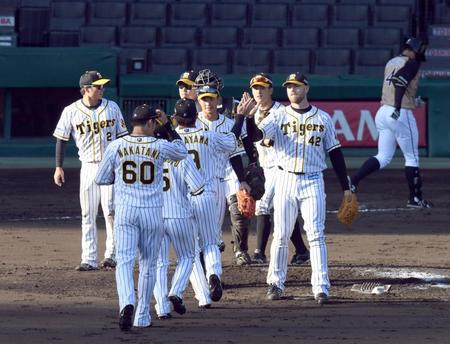 試合を締めた阪神ジョン・エドワーズ（右）はナインとタッチする＝甲子園（撮影・山口登）