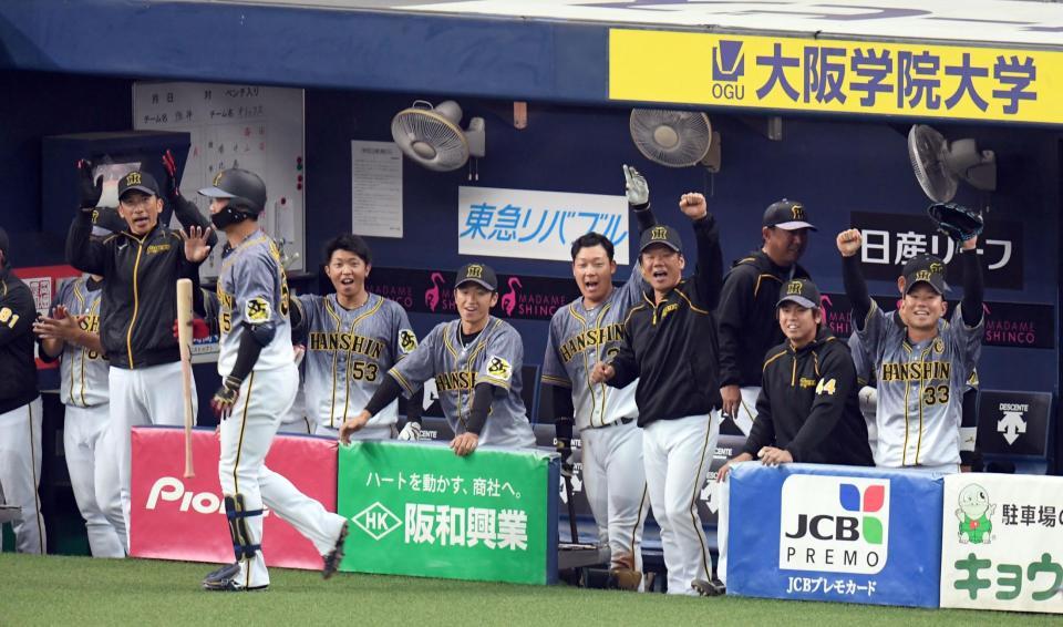 　８回、２死から植田（手前）が適時三塁打を放ち、手をたたいて喜ぶ矢野監督（左）ら阪神ベンチ