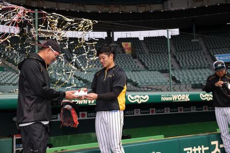 阪神・坂本誠志郎（右）が手作りのケーキを阪神・福留孝介に手渡す＝甲子園（阪神タイガース提供）