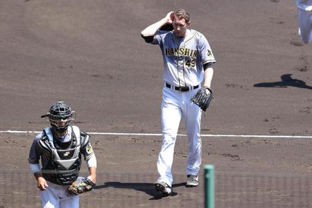 １回に１失点し、冴えない表情でベンチに引き揚げるガンケル。手前は梅野隆太郎（代表撮影）