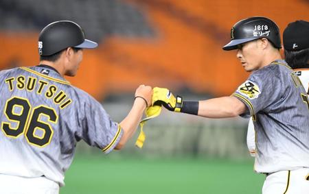 ８回、左前打を放った糸井（右）は筒井壮外野守備走塁コーチとグータッチ（撮影・中田匡峻）